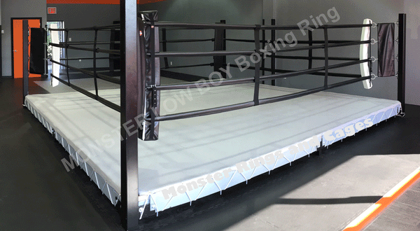 Pictured is an 18' Monster Lowboy boxing ring with short, 12", turnbuckle wraps in black.